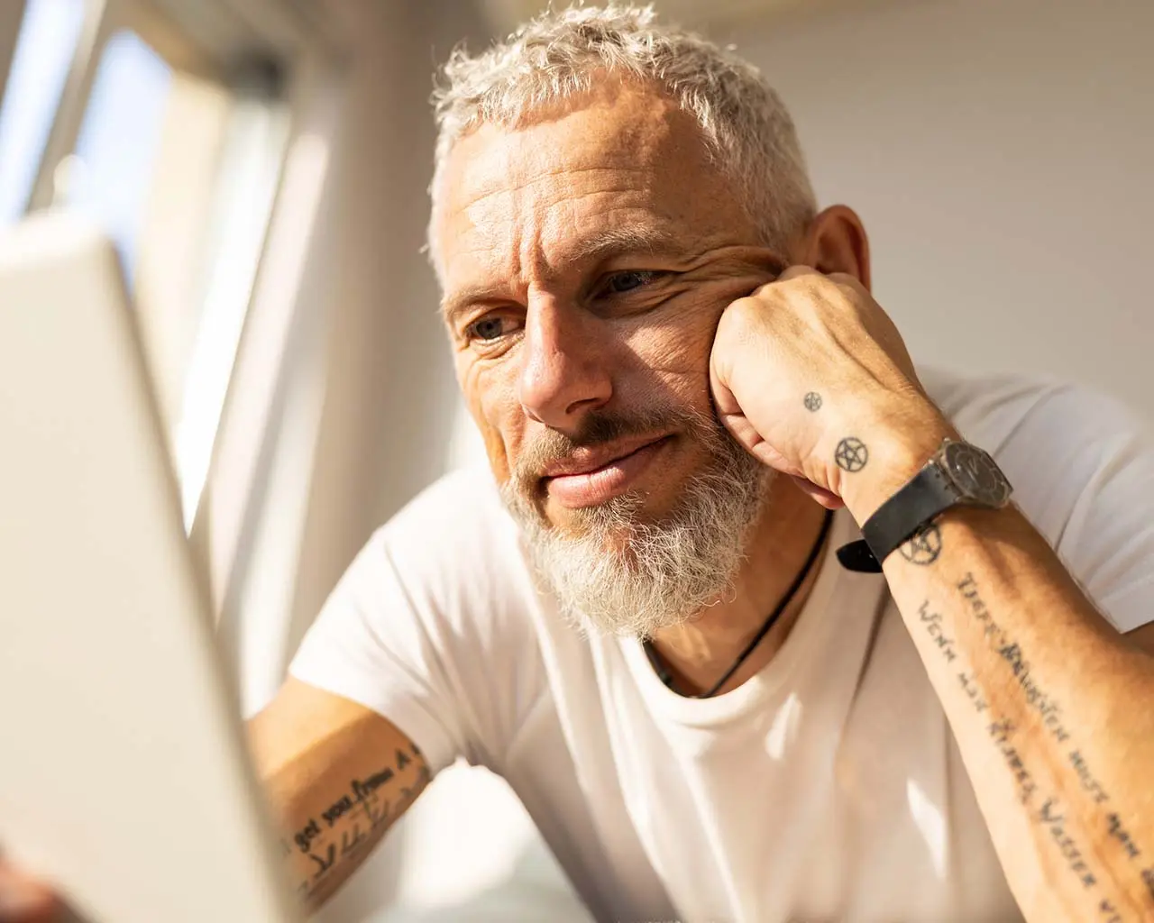 man with tattoo on computer working