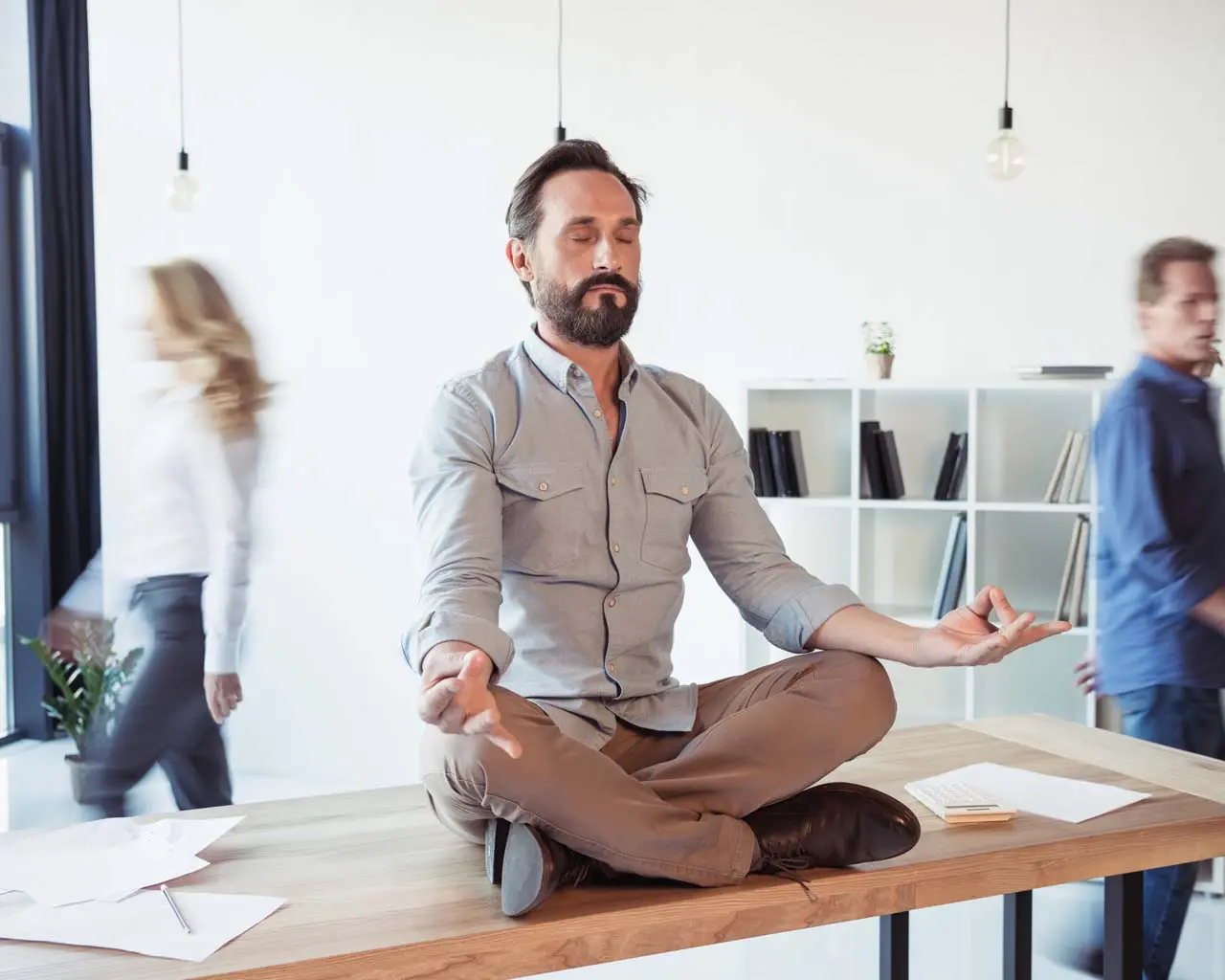 man meditating on office desk