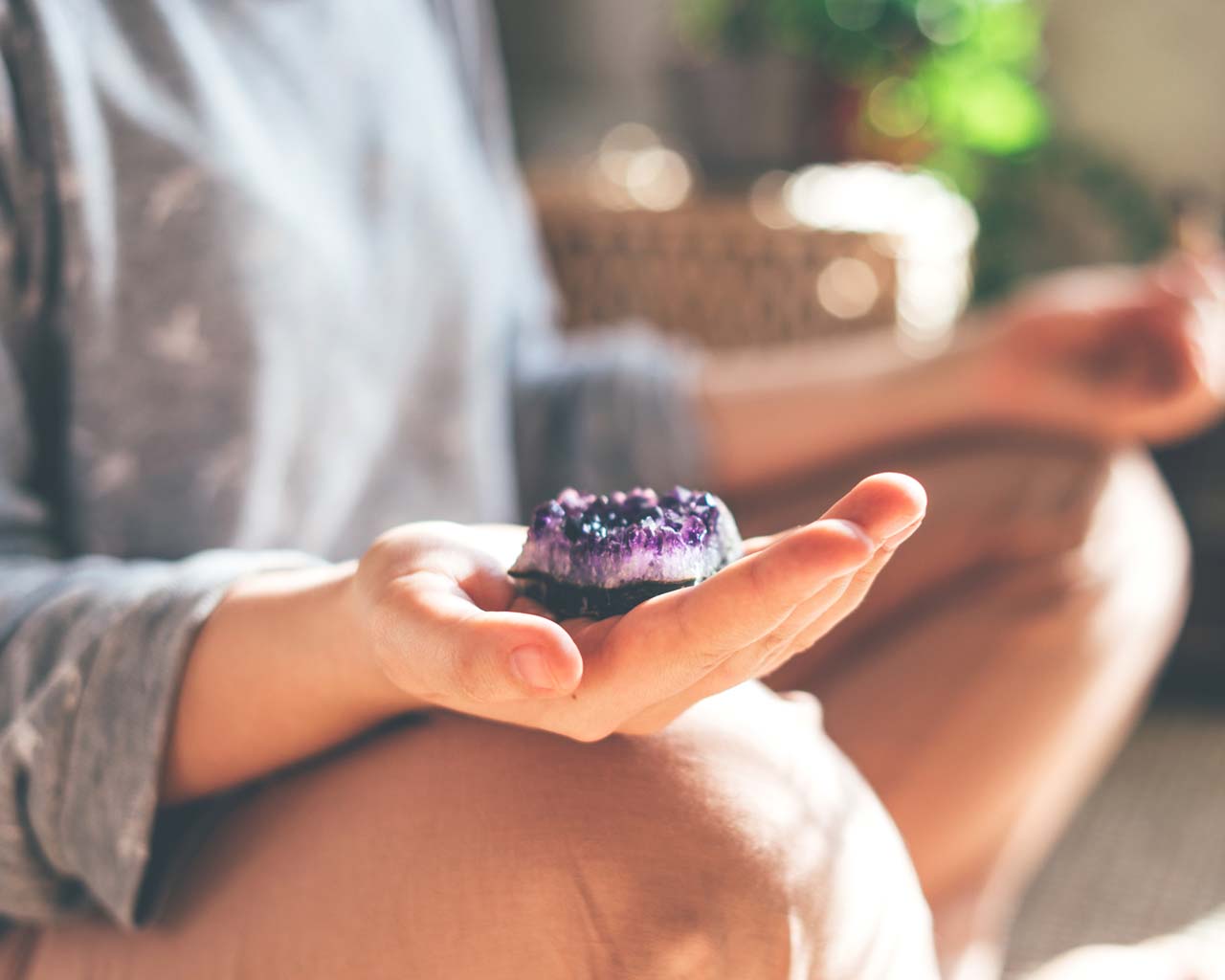 person meditating with crystal in hand